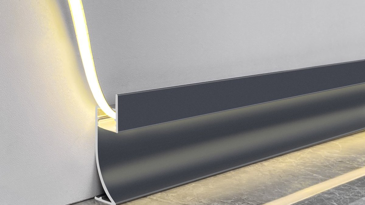 A black recessed LED baseboard lit along a marble wall